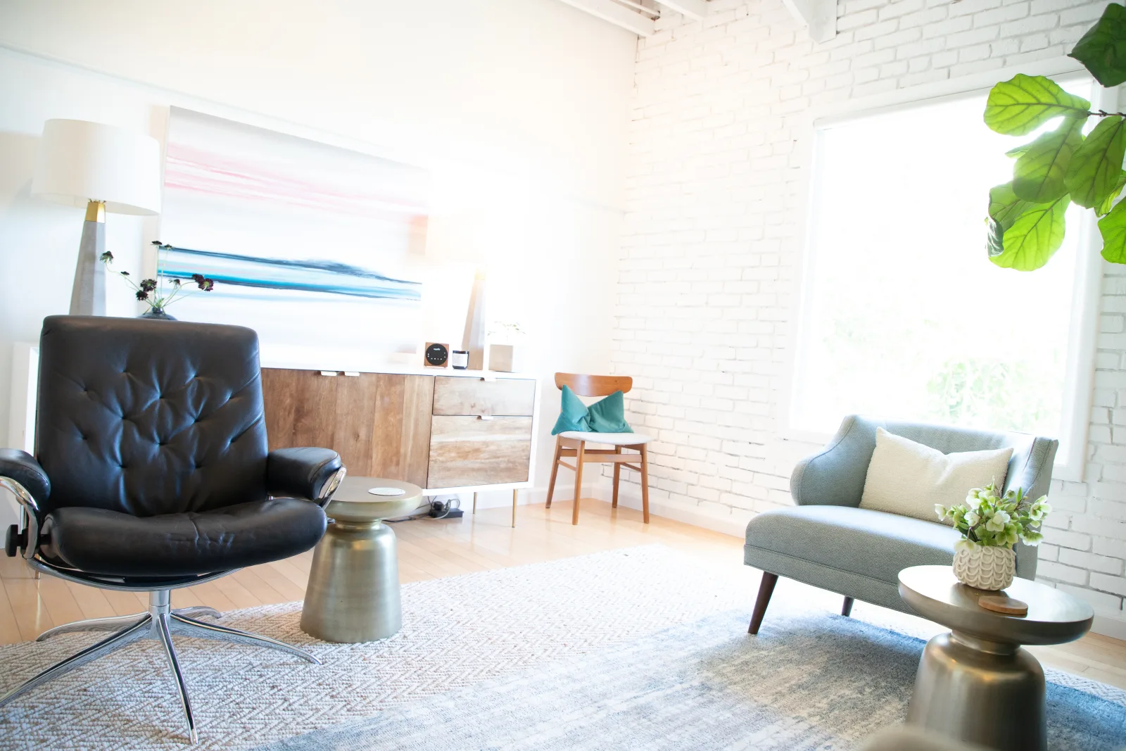 The therapy room at Cindy Weathers' West Hollywood office, with a leather chair, gray loveseat, and natural light